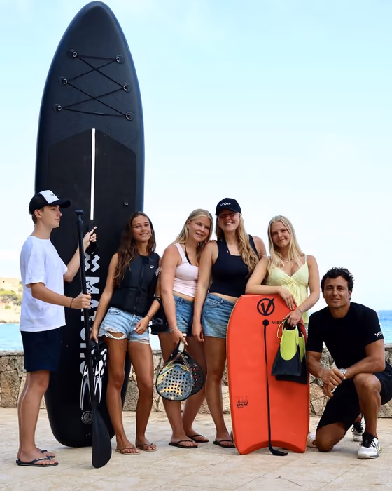 Leerlingen met SUP-board, padelrackets en bodyboard aan de kust van Palamós