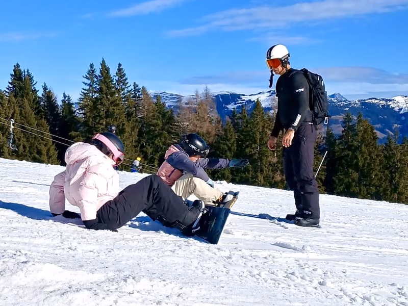 WOW-coach geeft snowboardles aan twee leerlingen op de piste