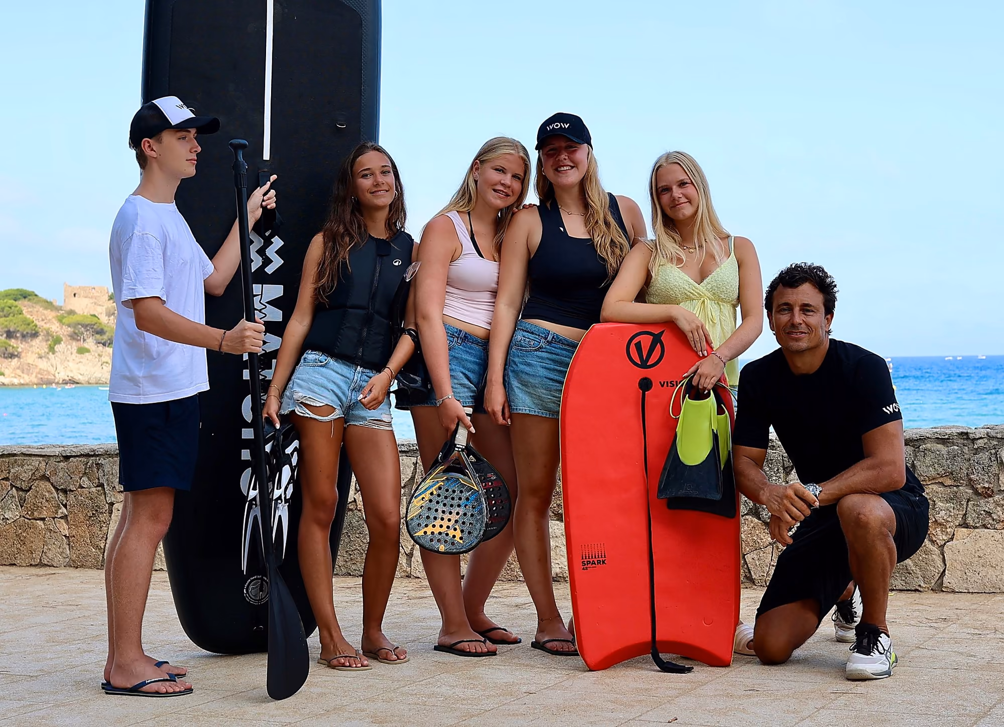 WOW instructeur begeleidt scholieren met suppboard, bodyboard en padelracket in Palamós, Spanje